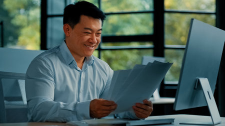 Emotional happy asian man businessman clerk specialist worker chinese korean male doing paperwork rejoice successful business deal throw toss papers up in office place get profitable contract documentの写真素材