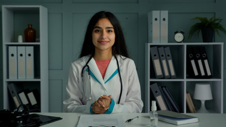 Professional young doctor arabian indian woman physician provide remote medical assistance in virtual chat. Medic female worker use video conference app consulting distant patient online webcam viewの写真素材