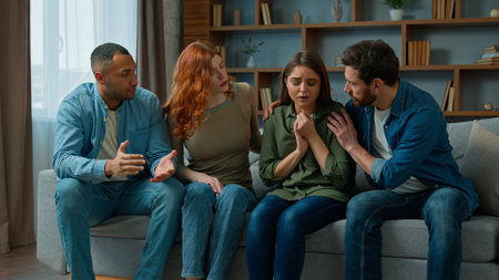 Desperate sad woman cry complain life problem diverse women and men colleagues buddies support stressed girl multiracial team sit on psychological therapy group meeting at home give help calm friendの写真素材
