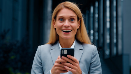 Close-up enthusiastic happy businesswoman receiving notification reading good news on telephone surprised excited woman saying wow winning lottery getting dream job great result rejoicing in victoryの写真素材