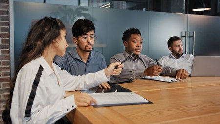 Multiracial female leader manager woman businesswoman talking to executive team diverse multiethnic group at boardroom office meeting. Multicultural business people discuss project financial resultの写真素材