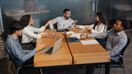 Office meeting briefing diverse staff members team workers colleagues managers sit at table in modern boardroom discuss project. Businesspeople negotiate analyzing sales stats results talking teamworkの写真素材