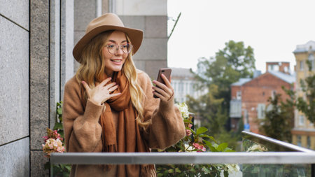 Shocked amazed wonder surprised Caucasian woman female lady looking at phone screen outdoors girl receive online offer notification message with mobile phone app feel shock surprise on balcony in cityの写真素材