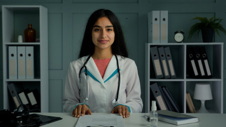 Professional young doctor arabian indian woman physician provide remote medical assistance in virtual chat. Medic female worker use video conference app consulting distant patient online webcam viewの写真素材