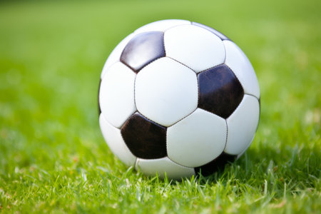 Soccer ball on ground grass stadium football game sport competition event championship match artificial green grass lawn grassy field outdoors calm empty sports ball isolated close-up backgroundの素材