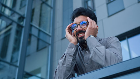 Overworked tired Arabian Indian business man businessman come on city balcony outside office suffer headache migraine hurt ache painful head pain strain health problem sick manager employer outdoorsの写真素材