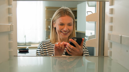 Point of view POV inside refrigerator Caucasian adult woman middle-aged female wife housewife open empty fridge order food with mobile delivery online service buying products with phone web store appの写真素材