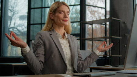 Calm Caucasian middle-aged adult woman meditation at workplace mindfulness mature business female relaxed lady businesswoman worker employer in office meditating zen break relax meditate no stressの写真素材