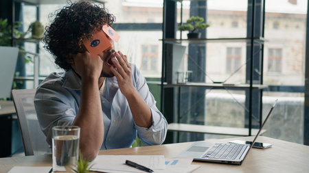 Funny lazy worker napping at office tired Arabian Indian business man sleeping covering eyes with...