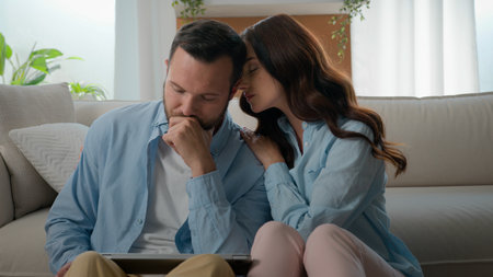 Caucasian man lost with laptop bad news receive email about work dismissal computer failure upset husband woman wife calming consoling supporting hugging lovely boyfriend couple at home family supportの写真素材