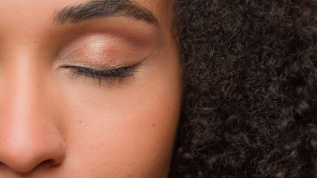 Beauty female portrait half of face close up eye beautiful make-up arrow eyelashes eyeliner eyelid mascara African American woman girl perfect skin natural complexion skincare cosmetics moisturizingの写真素材