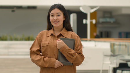 Asian chinese ethnic korean businesswoman employer in office company posing with digital tablet....