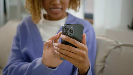 Cropped view smiling ethnic female on couch sofa at home chatting texting in social media order food...
