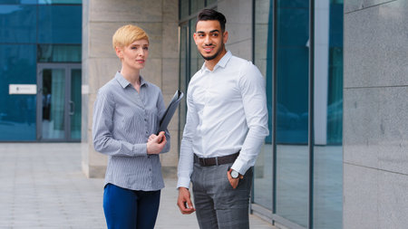 Multiethnic couple arabic indian business man and caucasian woman holding folder two colleagues...
