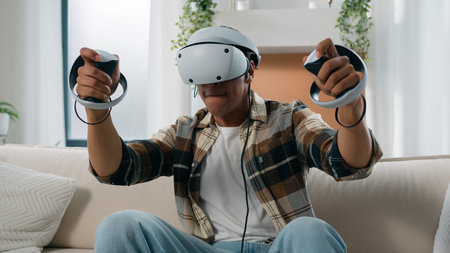 African American man having fun at home couch with virtual reality video game fight guy play 3d...