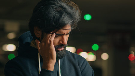 Close up stressed ill worried bad feeling unwell bearded Indian man take off glasses message head...