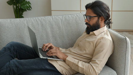 Arabian muslim man freelancer working from home focused millennial guy indian businessman typing on...