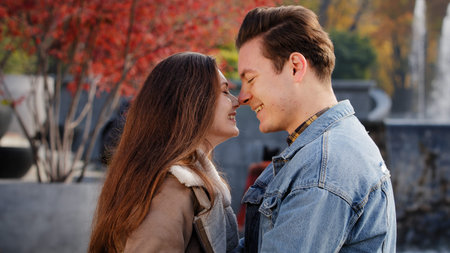 Gentle caucasian boyfriend man caress loved girlfriend woman talk about future outdoors stand...