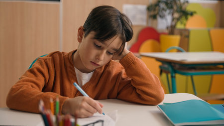 Little school boy primary schoolboy Caucasian son kid child clever smart writing task exercise at...