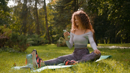 Caucasian woman sport girl fitness lady female at park nature outdoors in city relaxing on yoga mat...