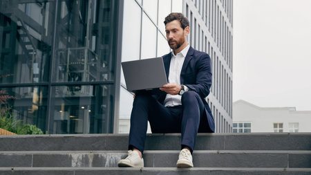 Successful businessman talking on video call on laptop negotiating conducting interview outdoors via...