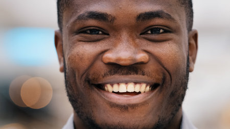 Close-up portrait young confident happy african american male client raises eyes looking at camera...