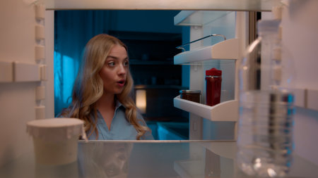 Point of view POV inside refrigerator Caucasian girl hungry woman open fridge at home kitchen look at empty shelves order food products delivery with mobile phone app online service web store shoppingの写真素材