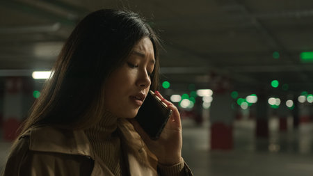 Worried upset Asian woman talk mobile phone in parking call worried talking disappointed smartphone...
