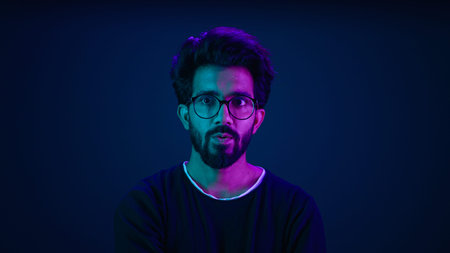 Male portrait neon background shocked amazed astonish wonder Indian man coder hacker computer...