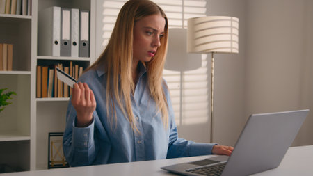 Confused puzzled client female hold bank credit card try to pay online annoyed with payment rejection problem wrong password. Worried girl woman trouble virtual money unsuccessful shopping with laptopの写真素材