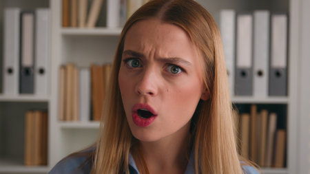 Shocked female face big eyes open mouth portrait amazed astonished stunned wonder astonish manager lady student girl in library surprised Caucasian woman unexpected news shock businesswoman in officeの写真素材