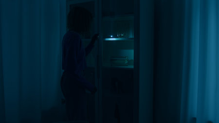 Confused unrecognizable woman girl walking in dark room night war blackout trouble search with light check closet electricity energy crisis outage searching lost with flashlight at home darkness crimeの写真素材