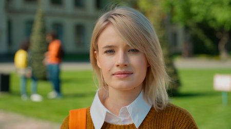 Portrait urban outdoor calm Caucasian student girl female woman lady pupil teen teenager standing in city outdoors university college high school academy campus education study learning holding bookの写真素材