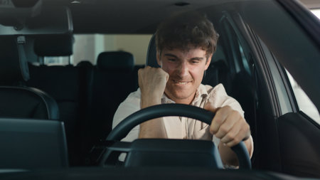 Smiling positive successful happy Caucasian man excited with new luxury car make winner hands gesture achieve triumph enjoy automobile buying male client buy vehicle transport celebrate sitting insideの写真素材