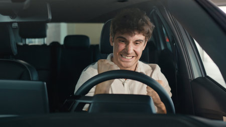 Smiling positive successful happy Caucasian man excited with new luxury car make winner hands...