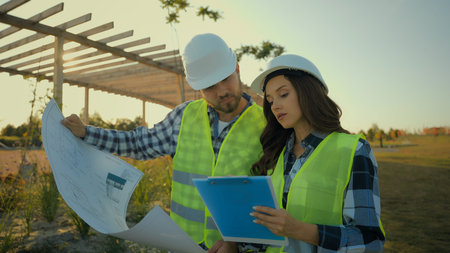 Caucasian contractors engineers colleagues female woman engineer inspector write report hardhat male...