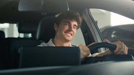 Happy Caucasian man driving new luxury electric crossover car in automobile salon dealership rejoice buy celebrate sitting inside cab auto transport credit loan emotions of happiness buyer achieveの写真素材