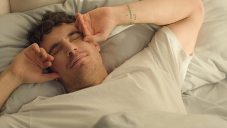 Caucasian happy man sleeping open eyes wake up looking at camera smiling good morning comfortable...