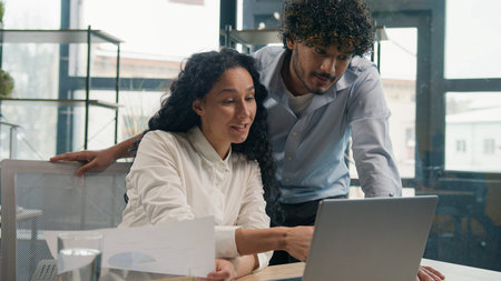 Indian businessman mentor coach help Arabian businesswoman with laptop teaching help explain online...