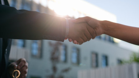 Closeup two people diverse multiracial man woman shake hands conclude successful contract agreement support partnership cooperation businessman and businesswoman greet on street business handshakingの写真素材