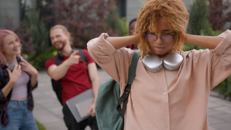 Group of angry students teenagers multiracial classmates at college university outdoors thumbs down African American sad woman student stressed girl problemの写真素材