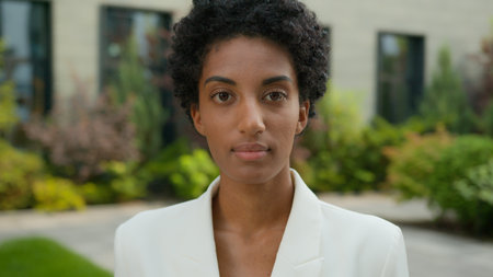 Close up portrait outdoors calm serious sad confident African American ethnic business woman feminist face looking camera stand in city student girl tranquil businesswoman female entrepreneur headshotの写真素材