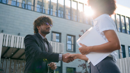 African American woman girl real estate manager trader saleswoman female realtor give bunch of keys to male client businessman customer man business rent delivery property in city buying apartmentの写真素材