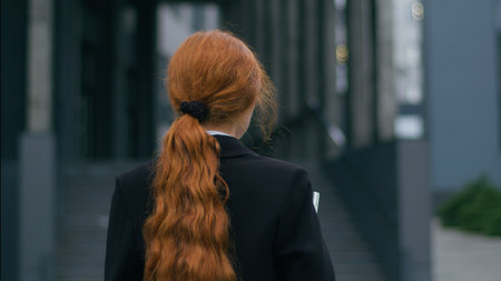 Happy smiling joyful Caucasian young female business woman girl employee CEO holding laptop device posing outside. Positive attractive businesswoman turning looking at camera wide smile outdoors cityの写真素材