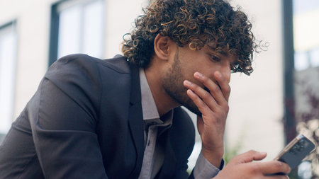 busy Arabian man Indian guy business entrepreneur tired exhausted worried stressed shocked businessman in city lost problem failure with mobile phone bad news outdoorsの写真素材