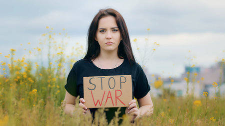 Sad caucasian brunette woman patriot raise placard with inscription stop war unhappy depressed girl...