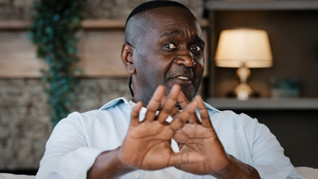 Dissatisfied upset shocked adult mature African American man feels aversion refusal gesture expressing disgust unpleasant reaction denial says no make frowning face waves hands covers faceの写真素材