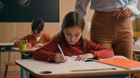 School class lesson children studying learning in classroom woman teacher female tutor walking...