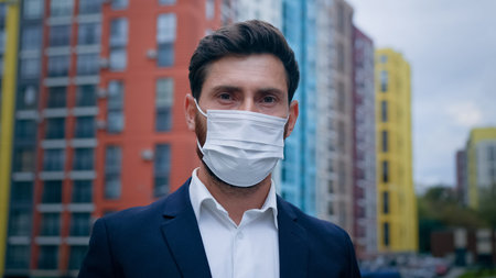 Close up portrait of businessman wearing medical mask put on face respirator follow quarantine...
