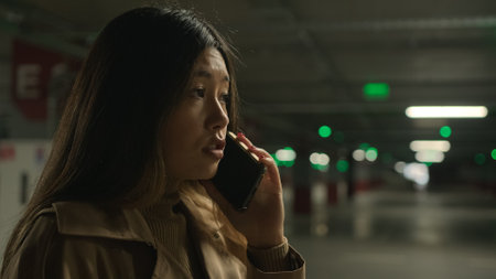 Worried upset Asian woman talk mobile phone in parking call worried talking disappointed smartphone conversation business problem chinese korean girl speak worry dissatisfied stressed trouble bad newsの写真素材